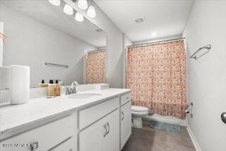 full bathroom featuring shower / tub combo with curtain, vanity, and toilet