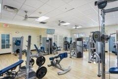 gym with hardwood / wood-style floors, a drop ceiling, and ceiling fan