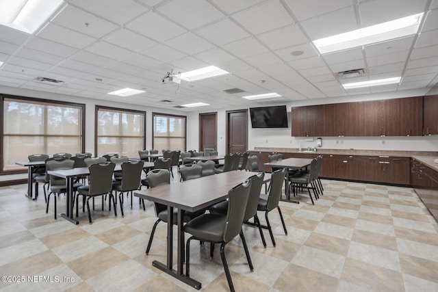 dining area with plenty of natural light and a drop ceiling