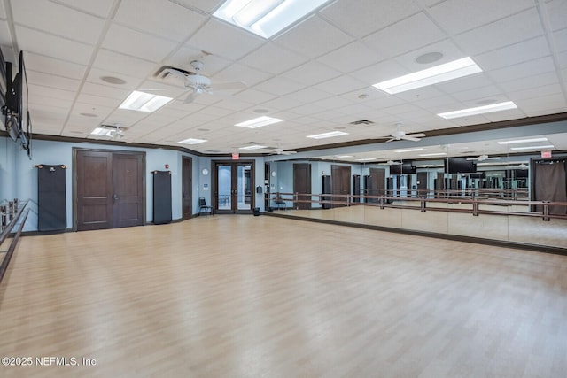 exercise room featuring hardwood / wood-style floors and a drop ceiling