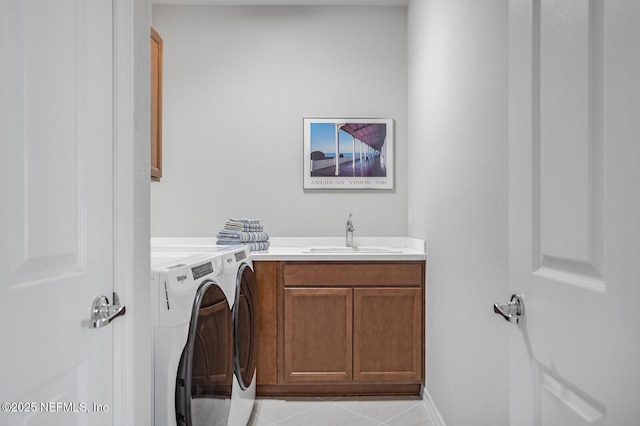 washroom featuring cabinets, washing machine and dryer, light tile patterned floors, and sink