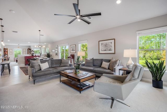 living room featuring ceiling fan with notable chandelier and light colored carpet