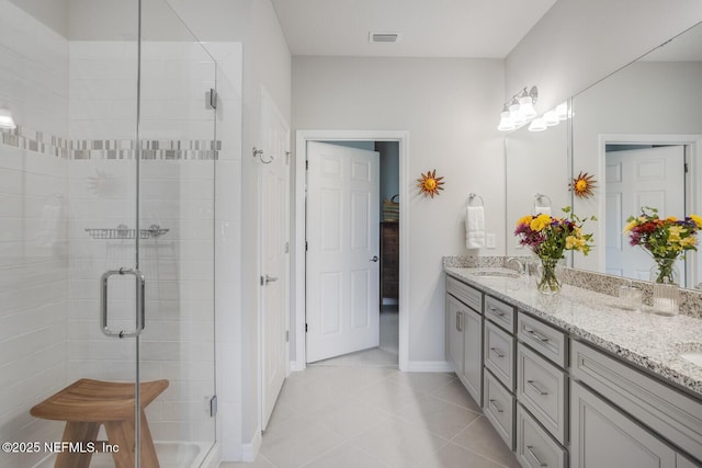 bathroom featuring tile patterned floors, a shower with door, and vanity