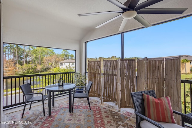 sunroom / solarium with ceiling fan and lofted ceiling