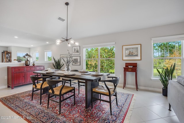 dining room featuring light tile patterned floors, a healthy amount of sunlight, and a notable chandelier