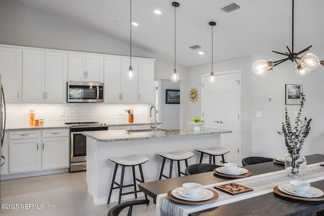 kitchen with backsplash, white cabinetry, sink, and stainless steel appliances