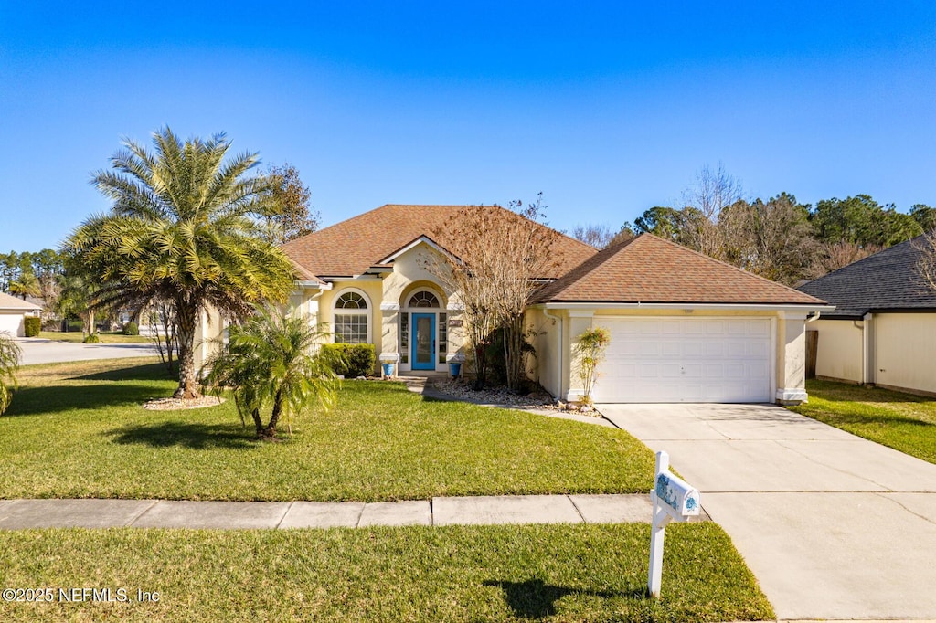 view of front of property with a front yard and a garage