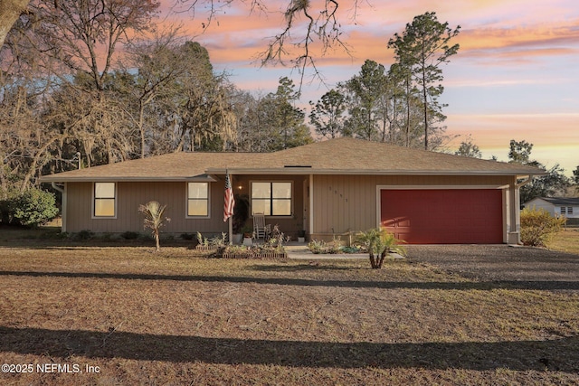 ranch-style home featuring a garage and a lawn