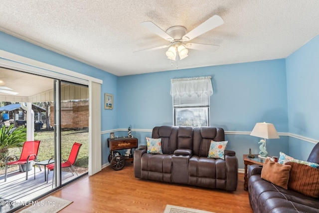 living room featuring hardwood / wood-style floors, a textured ceiling, and ceiling fan