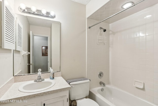 full bathroom with tiled shower / bath, vanity, and toilet