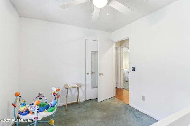 unfurnished bedroom featuring a textured ceiling, carpet floors, and ceiling fan