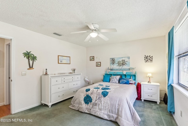 carpeted bedroom featuring ceiling fan and a textured ceiling