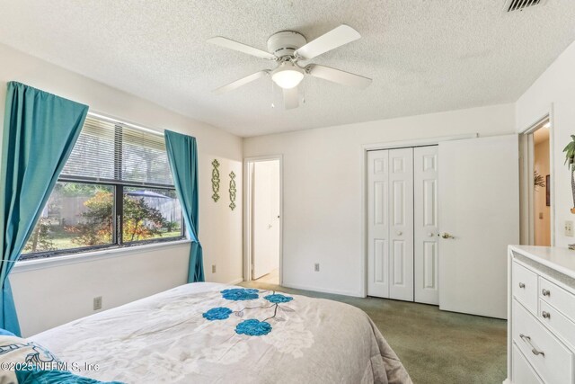 bedroom with ceiling fan, light carpet, a closet, and a textured ceiling