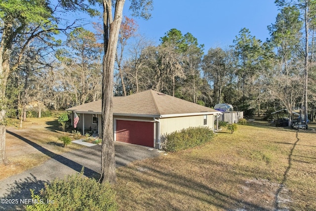 view of side of property with a garage and a lawn