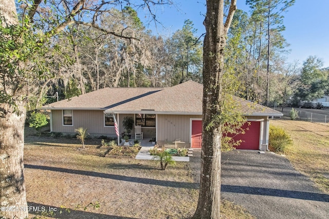 ranch-style house with a garage, covered porch, and a front yard