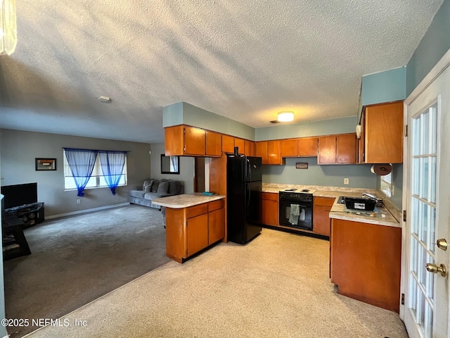 kitchen with black refrigerator, light colored carpet, wall oven, and sink