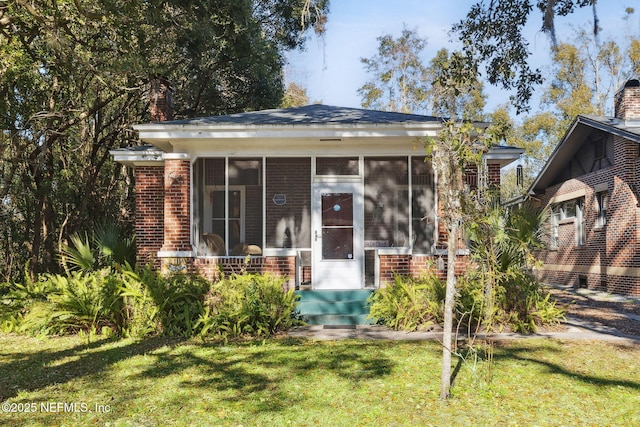 view of front facade featuring a sunroom and a front yard