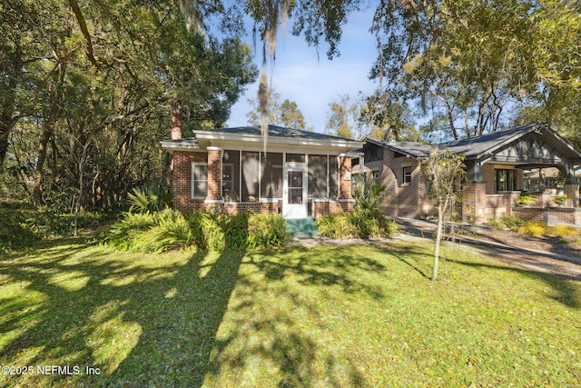 view of front of property with a sunroom and a front lawn