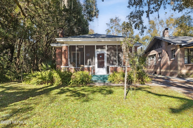 view of front of home featuring a sunroom and a front yard