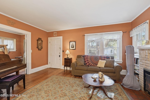 living room with light hardwood / wood-style flooring, a brick fireplace, and crown molding