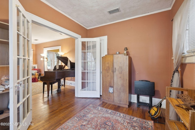 miscellaneous room with dark hardwood / wood-style floors, ornamental molding, a textured ceiling, and french doors