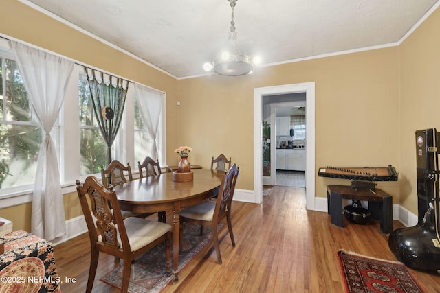 dining room featuring hardwood / wood-style floors, an inviting chandelier, and ornamental molding