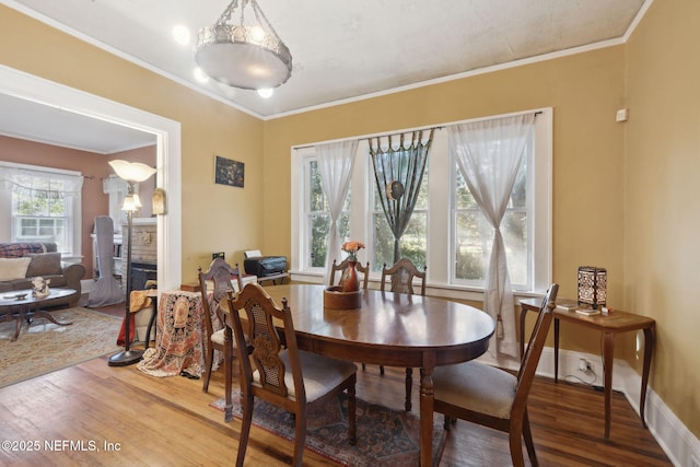 dining area with plenty of natural light, wood-type flooring, and crown molding