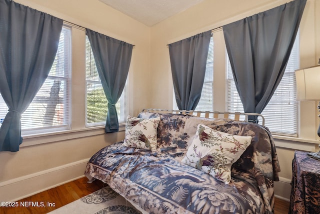 bedroom featuring hardwood / wood-style flooring and multiple windows