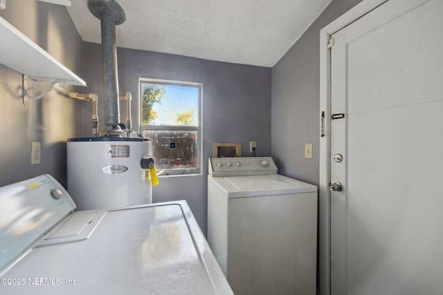 clothes washing area with independent washer and dryer, a textured ceiling, and water heater