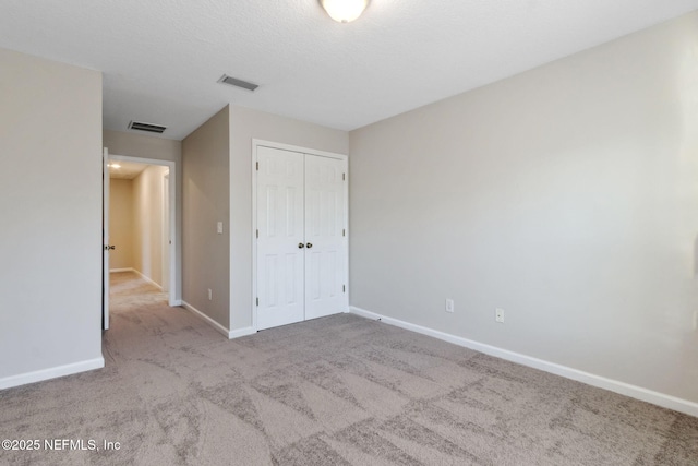 unfurnished bedroom featuring a closet and light carpet