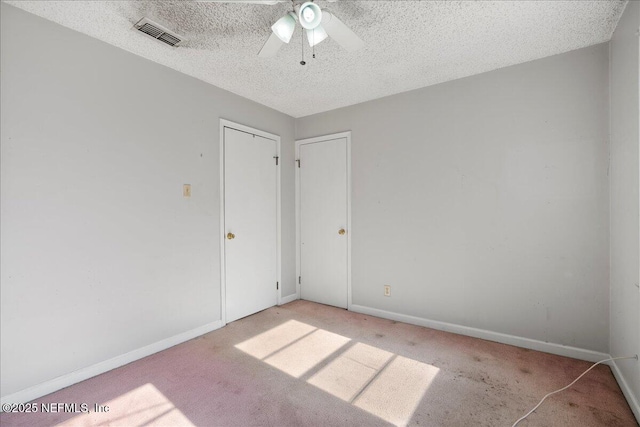 carpeted empty room featuring ceiling fan and a textured ceiling