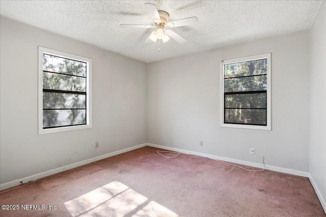 spare room featuring light carpet, a textured ceiling, plenty of natural light, and ceiling fan