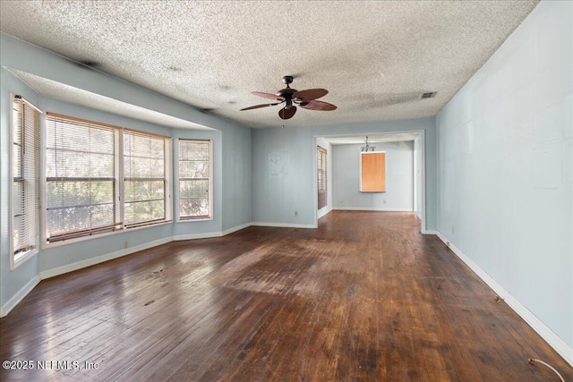 unfurnished room with ceiling fan, dark wood-type flooring, and a textured ceiling