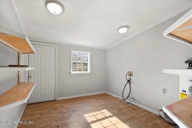 interior space with hookup for a washing machine, hardwood / wood-style floors, and ornamental molding