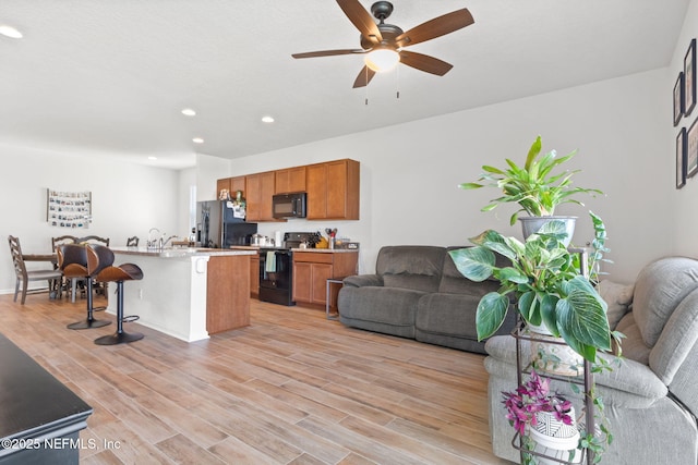 living room featuring light hardwood / wood-style flooring and ceiling fan