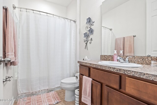 bathroom featuring vanity, toilet, and walk in shower