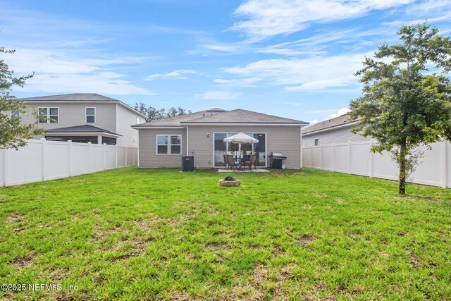 back of property with a yard, an outdoor fire pit, and cooling unit