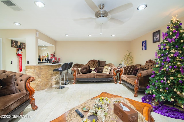 living room featuring light tile patterned floors, indoor bar, and ceiling fan