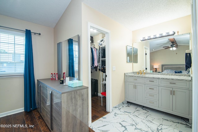 bathroom featuring ceiling fan, a textured ceiling, and vanity