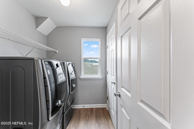 clothes washing area featuring dark hardwood / wood-style floors, a textured ceiling, and washing machine and clothes dryer