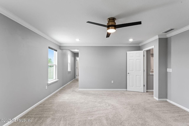 spare room featuring ceiling fan, crown molding, and light carpet