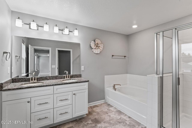 bathroom featuring vanity, separate shower and tub, and a textured ceiling