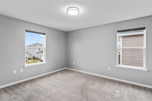 carpeted empty room with a textured ceiling