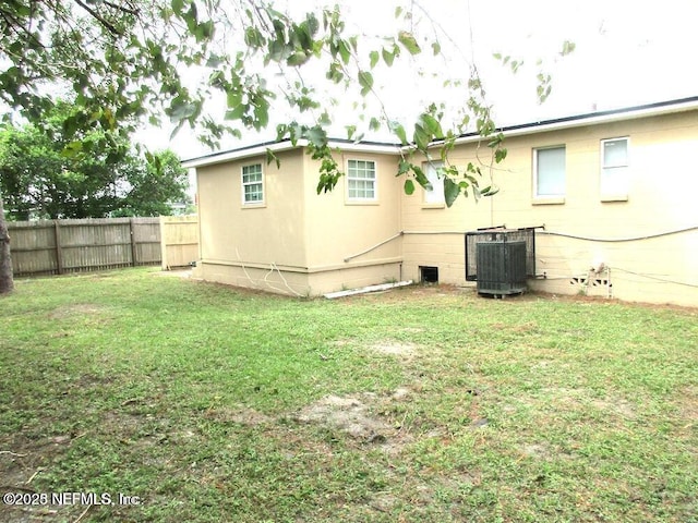 rear view of house featuring a yard and cooling unit