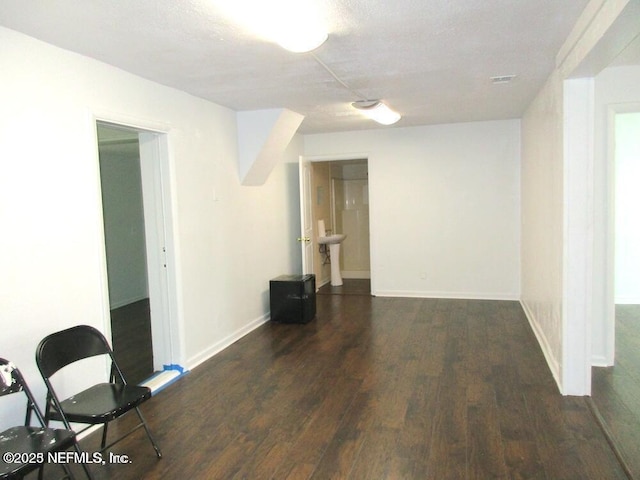 unfurnished room with a textured ceiling and dark hardwood / wood-style floors