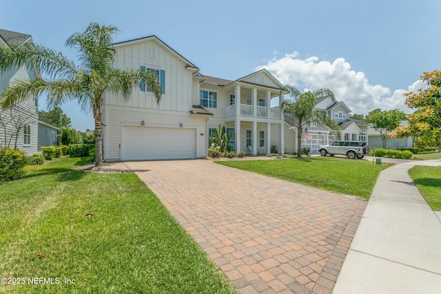 view of front of property featuring a garage, a balcony, and a front lawn