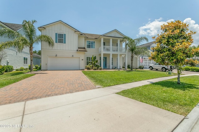 view of front of home featuring a balcony, a garage, and a front lawn