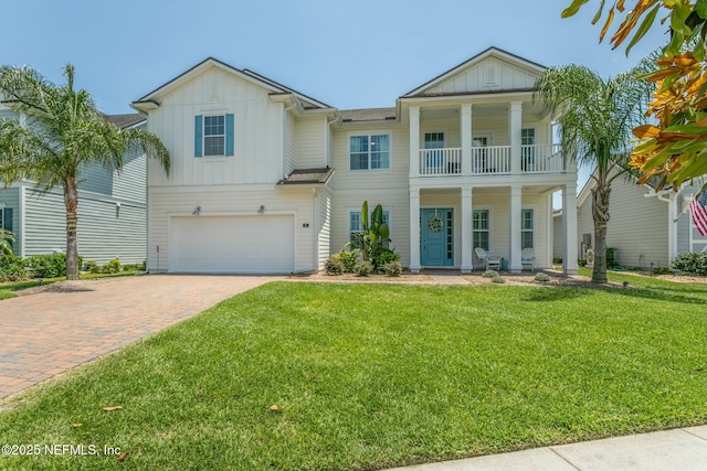 view of front of property with a garage, a balcony, and a front lawn