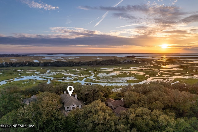 aerial view at dusk featuring a water view