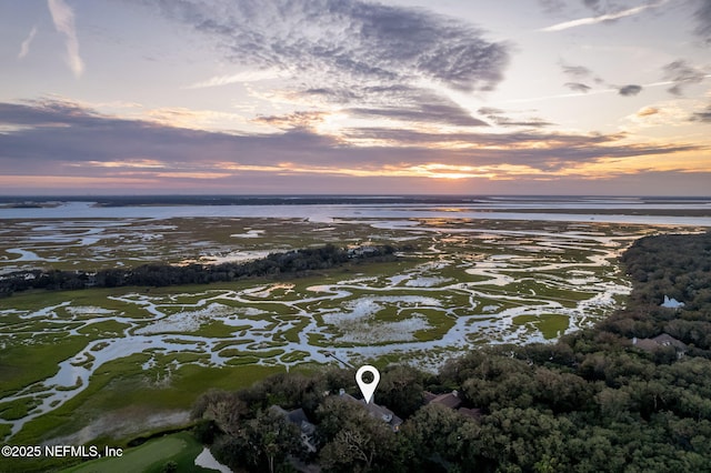 aerial view at dusk featuring a water view